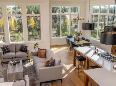 View of beautifully modeled kitchen and living area with many windows and lots of natural light.